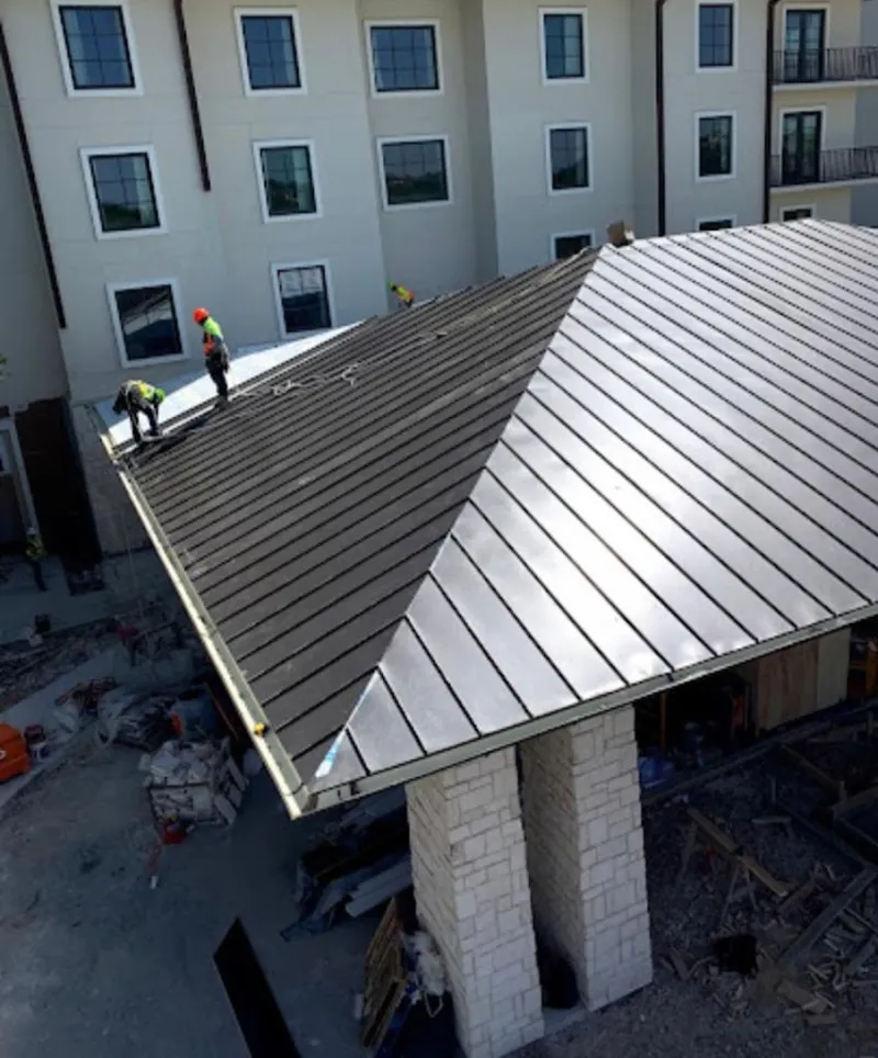 Crew installing standing seam metal roof panels on a commercial project in New Carrollton